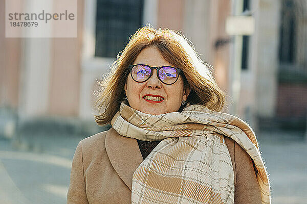 Glückliche ältere Frau mit Schal und Brille