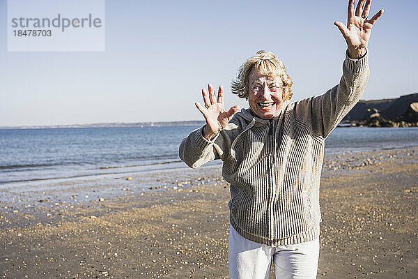 Fröhliche ältere Frau am Strand im Urlaub