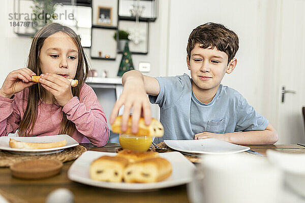 Bruder und Schwester frühstücken am Tisch