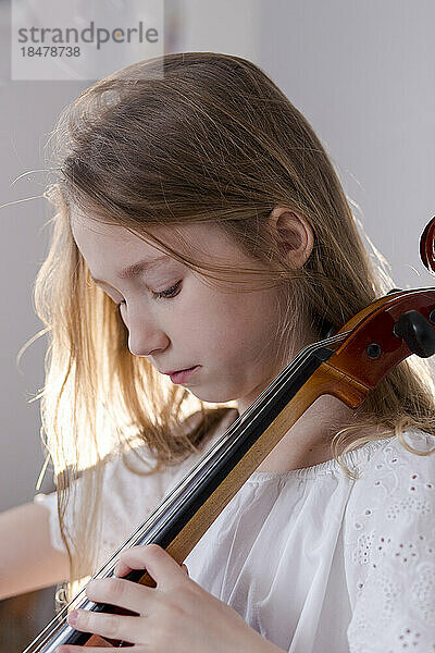 Mädchen übt zu Hause Cello