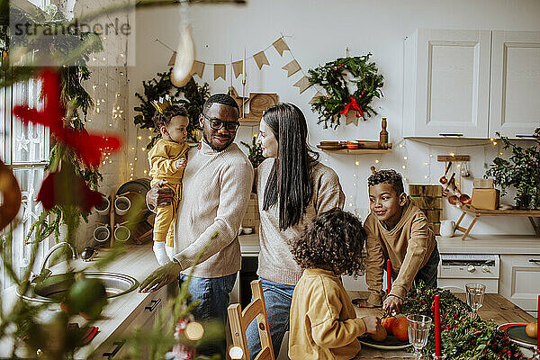 Glückliche Eltern verbringen Weihnachten Zeit mit Sohn und Töchtern in der Küche