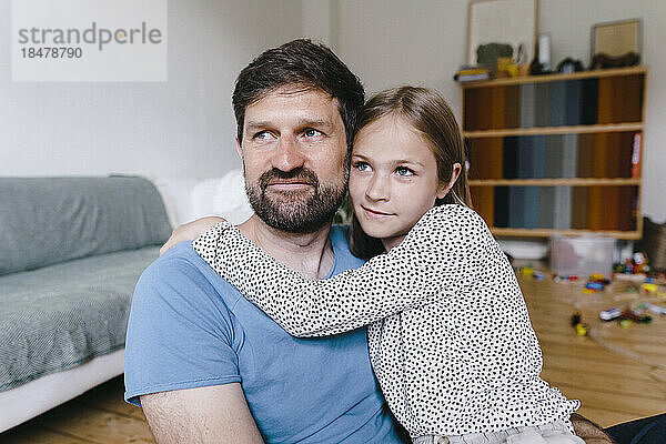 Nachdenkliche Tochter sitzt mit Vater zu Hause