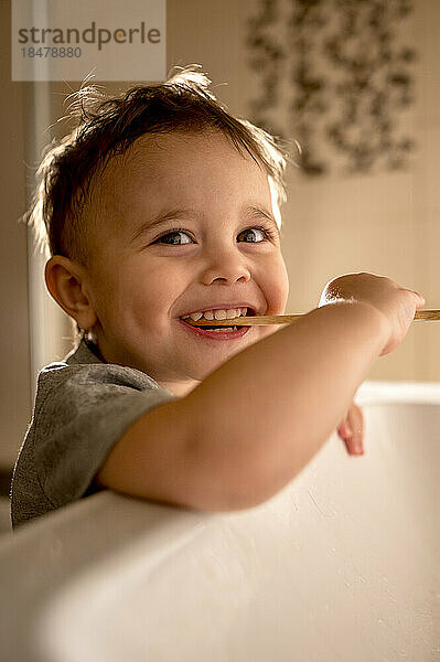 Junge putzt Zähne am Waschbecken im Badezimmer