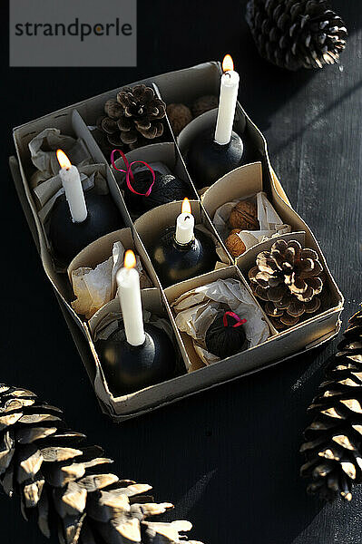 DIY geteilte Pappschachtel mit Walnüssen  Tannenzapfen und brennenden Kerzen