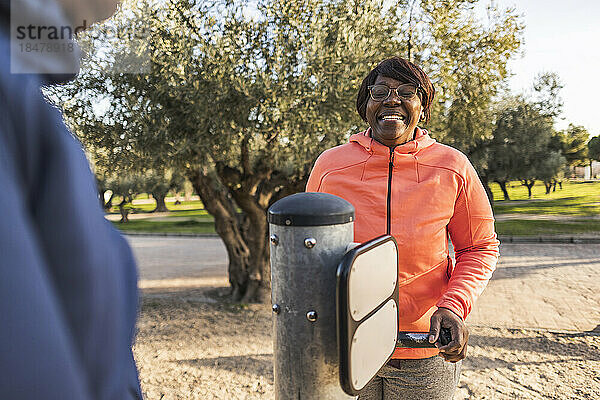 Glückliches Seniorenpaar trainiert mit Outdoor-Geräten im Park