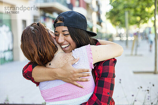 Glückliche Frau umarmt Lesbe auf Fußweg