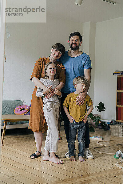 Glückliche Familie  die zu Hause zusammen im Wohnzimmer steht
