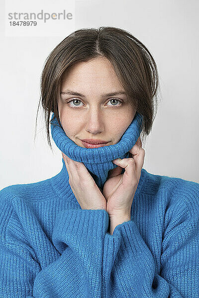 Confident woman wearing turtleneck against white background
