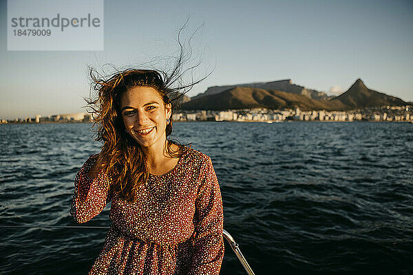 Glückliche Frau vor dem Meer an einem sonnigen Tag