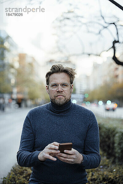 Mann mit Smartphone und Brille