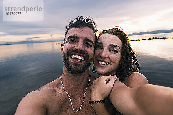 Glückliches Paar macht gemeinsam ein Selfie am Strand