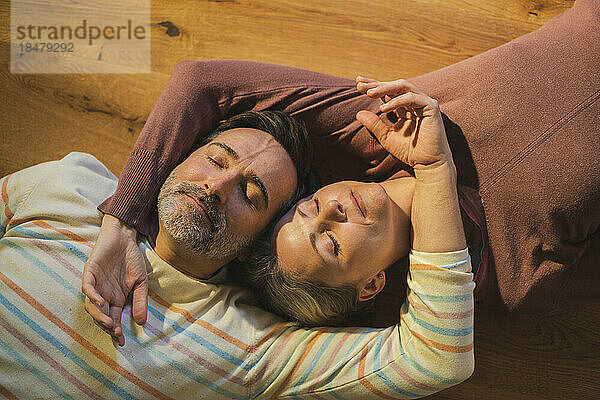 Man and woman lying down on floor at home