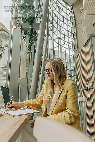 Freiberufler schreibt Tagebuch im Café