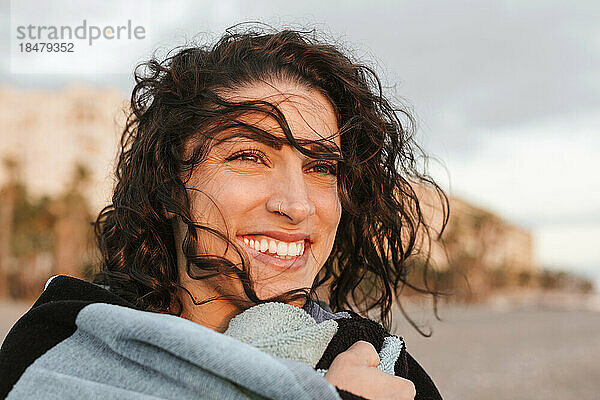 Fröhliche  nachdenkliche junge Frau am Strand