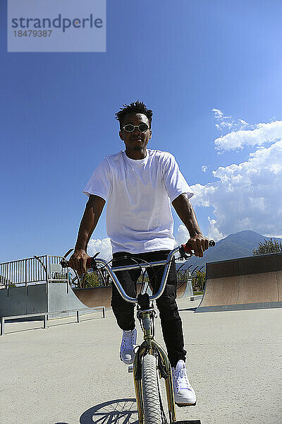 Mann fährt BMX-Fahrrad an sonnigem Tag im Skatepark