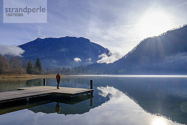 Austria  Lower Austria  Lunz am See  Man admiring sunrise over Lunzer See lake from edge of jetty