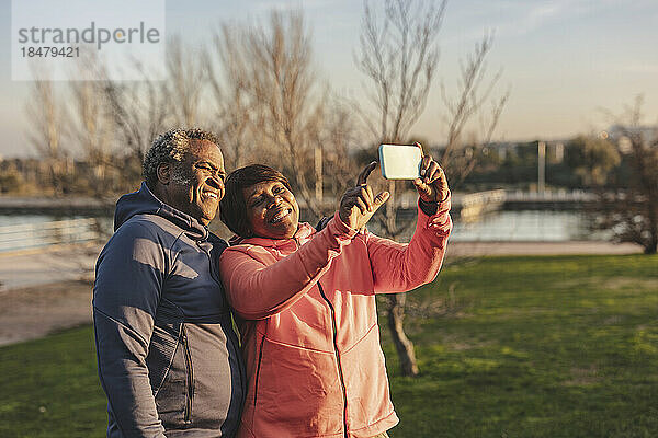 Glückliches älteres Paar  das im Park ein Selfie mit dem Smartphone macht