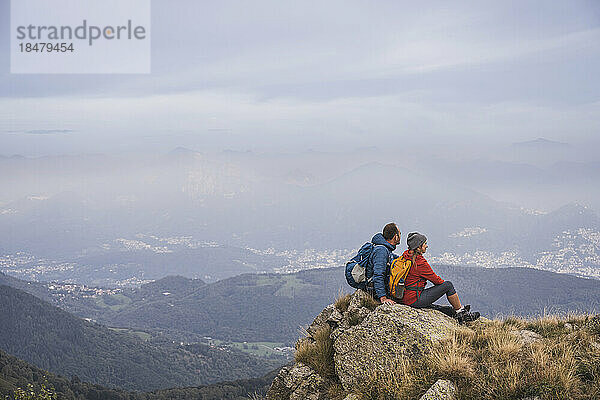 Reifer Mann und Frau sitzen auf einem Felsen