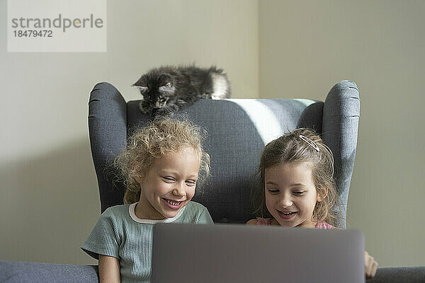 Glückliche Mädchen  die zu Hause Laptop schauen