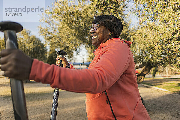 Ältere Frau trainiert mit Outdoor-Geräten im Park