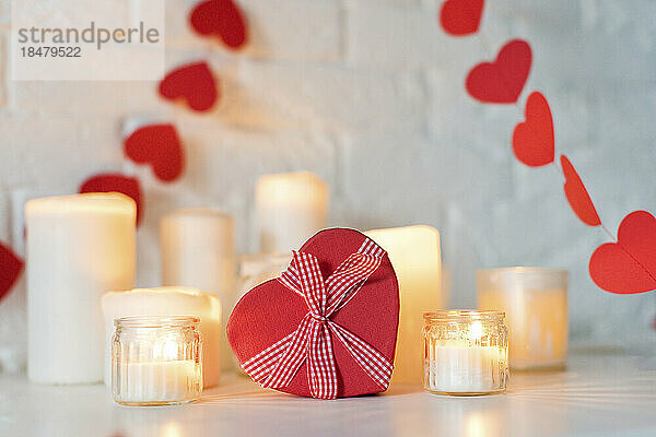 Herzförmige Geschenkbox mit Kerzen auf dem Tisch