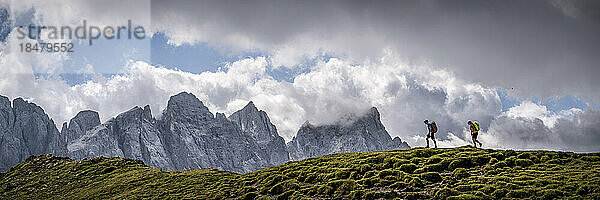 Mann und Frau wandern unter bewölktem Himmel in der Forcella Venegia  Dolomiten  Italien