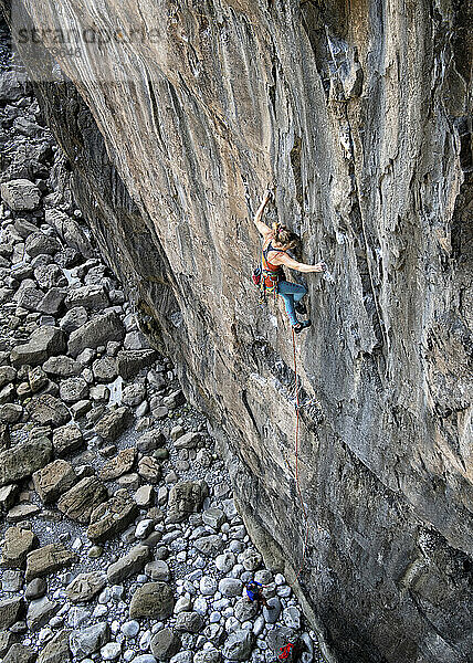 Aktive Frau klettert an Felswand