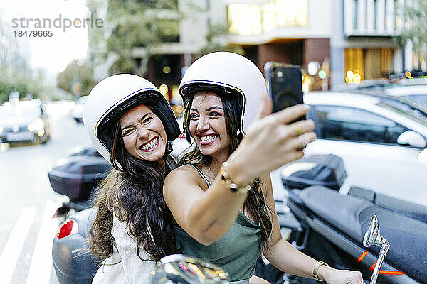 Fröhliche Frau mit Helm macht Selfie per Smartphone