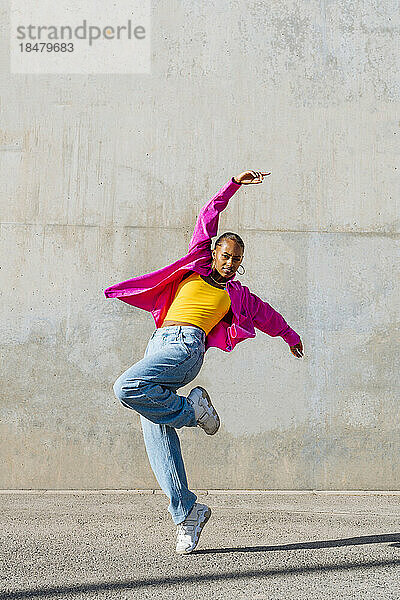 Junger Hip-Hop-Tänzer tanzt auf Fußweg