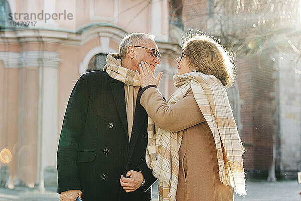 Romantic senior woman touching cheek of man