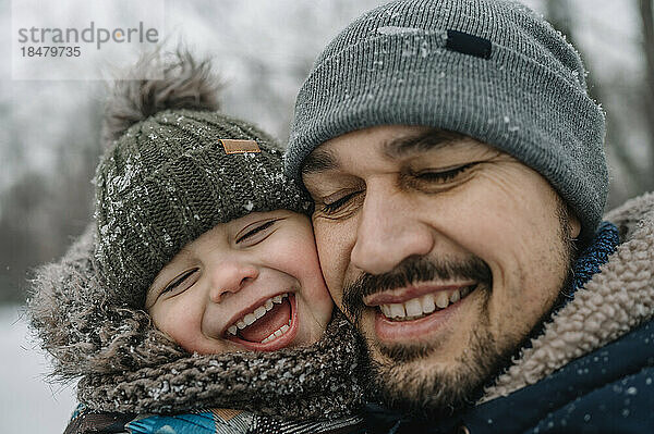 Vater und Sohn haben Spaß im Schnee