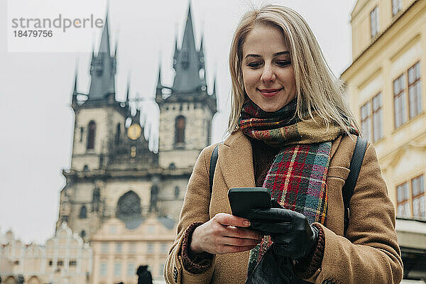 Lächelnde Frau  die mit ihrem Smartphone im Internet surft