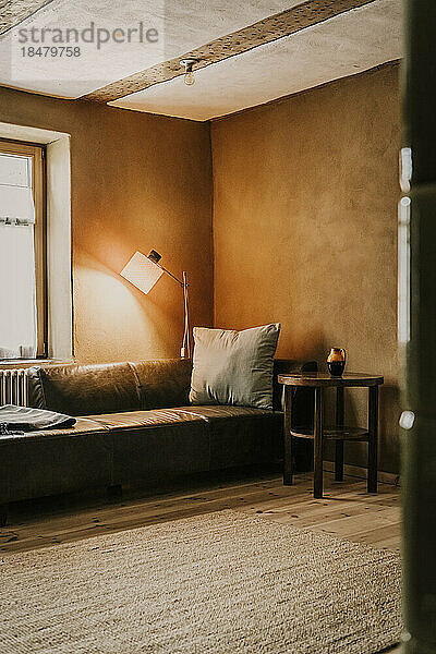 Sofa und beleuchtete Lampe im Wohnzimmer
