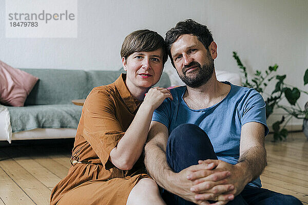 Smiling mature couple sitting in living room at home