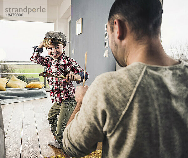 Glücklicher Vater und Sohn  die zu Hause mit Spateln spielen