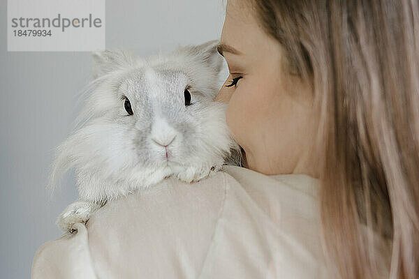 Woman kissing rabbit at home