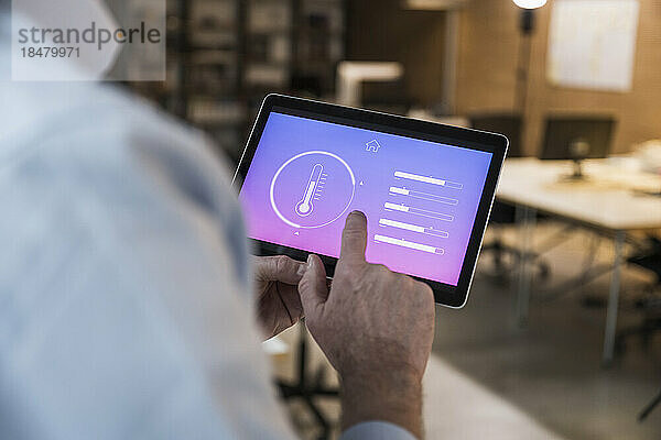 Geschäftsmann nutzt Automatisierungs-App auf Tablet-PC im Büro