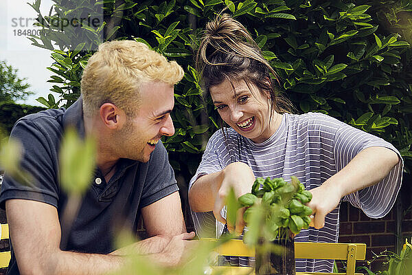 Happy couple talking to each other doing gardening in back yard