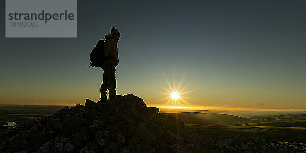 Silhouette eines Mannes auf einem Berggipfel bei Sonnenuntergang  Preseli Hills  Pembrokeshire  Wales