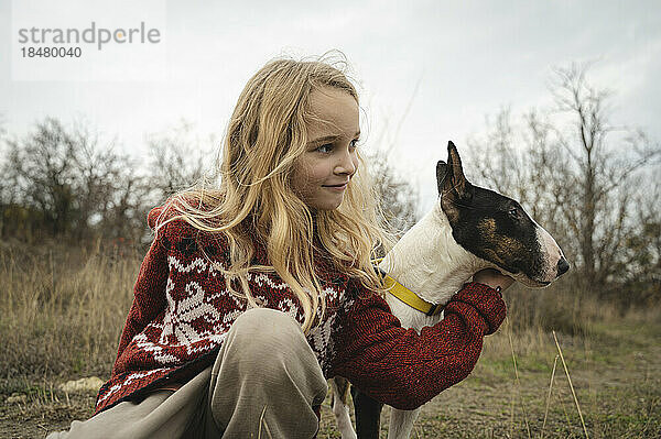 Blond girl playing with dog