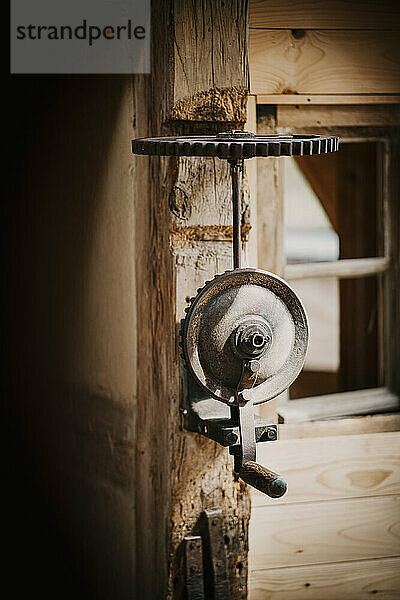 Old metal machine mounted on wooden wall