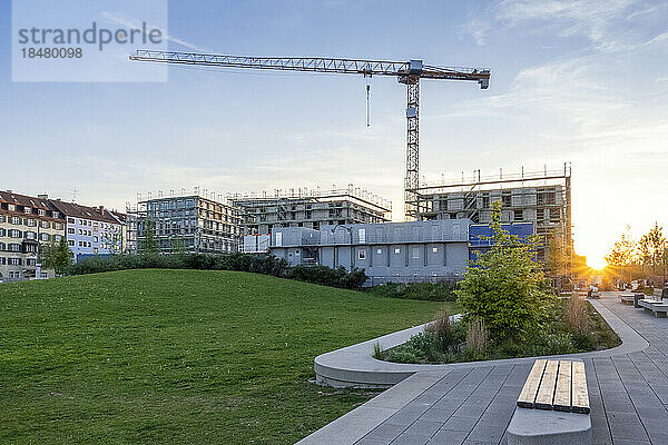 Deutschland  Bayern  München  Baustelle eines modernen Mehrfamilienhauses bei Sonnenuntergang