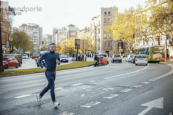 Mann rennt und überquert Straße in der Stadt