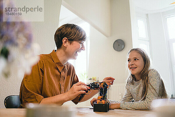 Happy woman with robotic arm looking at daughter in home