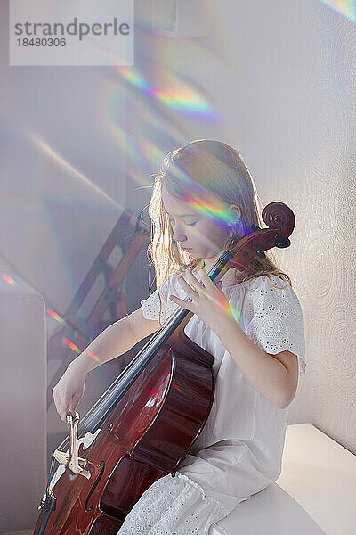 Mädchen spielt zu Hause Cello