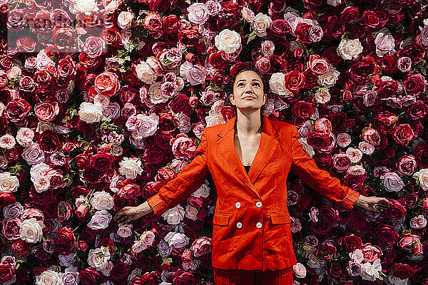 Businesswoman with arms outstretched over flowers