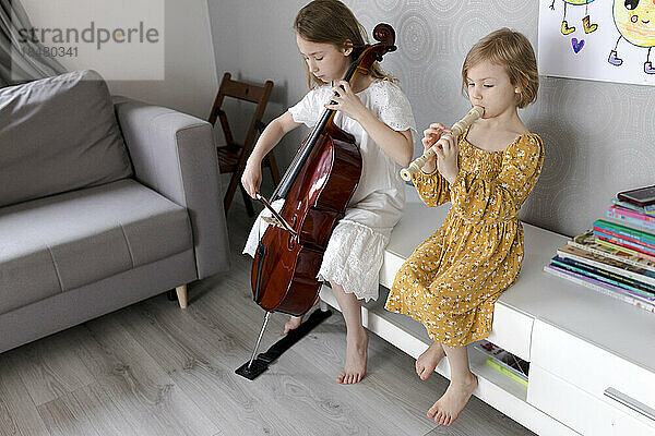 Schwestern spielen zu Hause Musikinstrumente