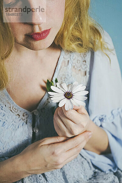 Blonde Frau hält weiße Blume