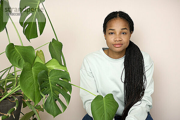Young woman with braided hair by plants