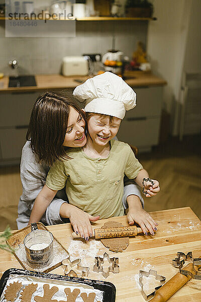 Glückliche Mutter und Sohn backen zu Hause Ingwerkekse